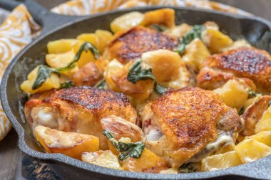 Kızartma tavuk, patates ve ıspanak bir tavada krem sos ile