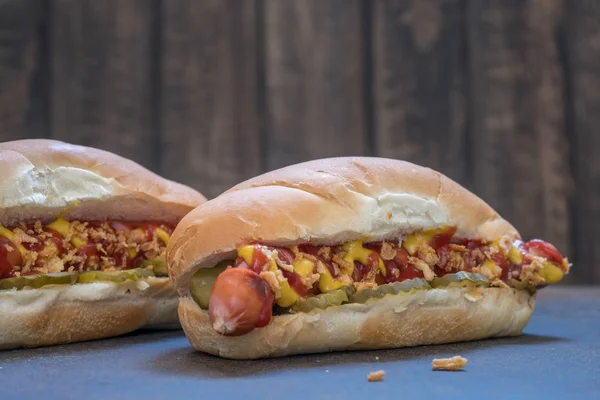 Grilled hot dogs with mustard, ketchup and dill pickles — Stock Photo, Image