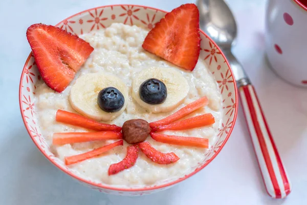 Oatmeal porridge with a kitten face decoration — Stock Photo, Image