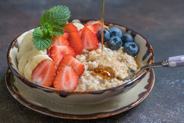 Bowl of delicious steel cut oats with fresh fruit, honey