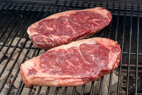 Raw beef steaks on a grill — Stock Photo, Image