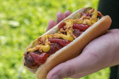 Sosisli sarılmış domuz pastırması sosis, ketçap, sarı hardal, kızarmış soğan ve turşu