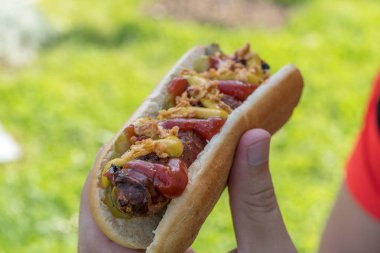 Sosisli sarılmış domuz pastırması sosis, ketçap, sarı hardal, kızarmış soğan ve turşu