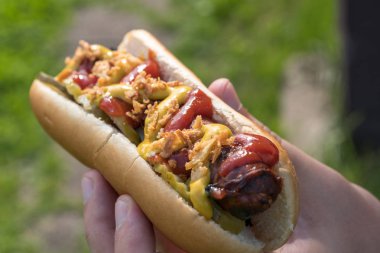 Sosisli sarılmış domuz pastırması sosis, ketçap, sarı hardal, kızarmış soğan ve turşu