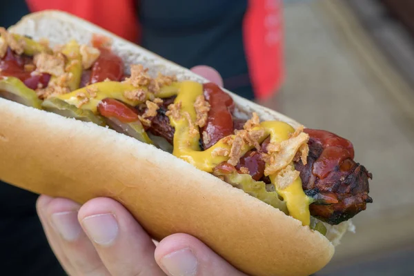 Hot Dog z boczku owinięte kiełbasa, ketchupu, musztardy, smażony cebulę i ogórki — Zdjęcie stockowe