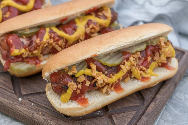 Hot Dog s slanina, klobása, kečup, hořčice žlutá, smažené cibule a okurky — Stock fotografie