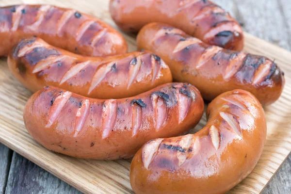 Grilled sausage on a wooden board — Stock Photo, Image