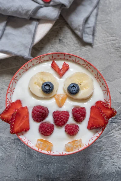 Děti legrační snídani jogurt s ovocem a bobule — Stock fotografie