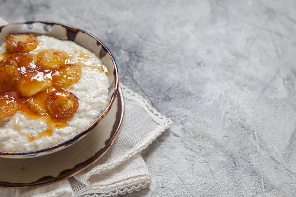 Bowl of oatmeal porridge with banana and honey — Stock Photo, Image