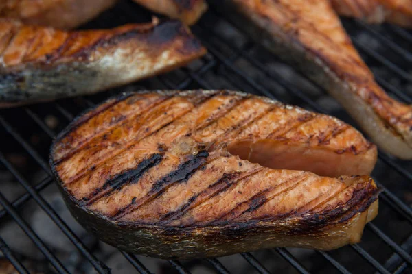 Bifes de peixe vermelho de salmão grelhado na grelha flamejante — Fotografia de Stock