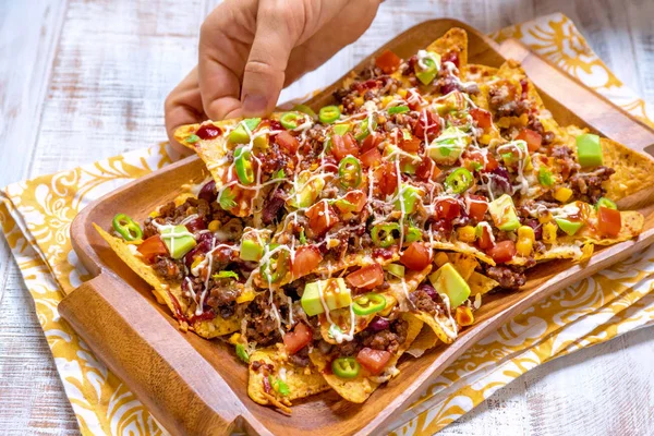 Tortillas de maíz amarillo de nacho mexicano con queso, carne, guacamole de aguacate y salsa roja —  Fotos de Stock