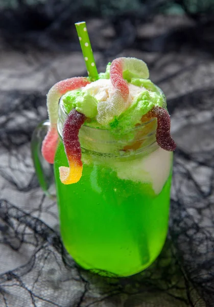 Bevanda verde con gelato galleggiante e vermi gommosi per Halloween — Foto Stock