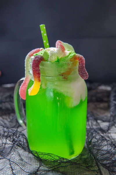 Bevanda verde con gelato galleggiante e vermi gommosi per Halloween — Foto Stock