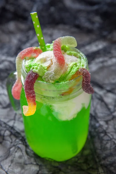 Grünes Getränk mit Eiswagen und Gummiwürmern zu Halloween — Stockfoto