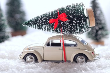 Bir Noel ağacı karla kaplı minyatür herdem yeşil orman içinde taşıyan araba