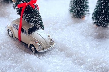 Bir Noel ağacı karla kaplı minyatür herdem yeşil orman içinde taşıyan araba