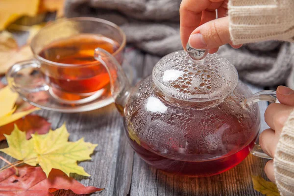 Autumn Still Life: Tea on maple leaves on a wooden table — Stock Photo, Image