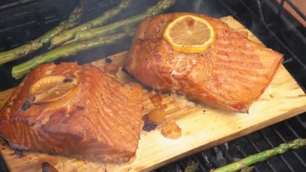 Кедровая доска лосось с лимоном приготовления на гриле — стоковое видео