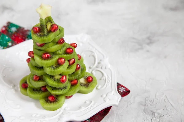 Gesunde Dessertidee für Kinderfest - lustiger essbarer Kiwi-Granatapfel-Weihnachtsbaum — Stockfoto