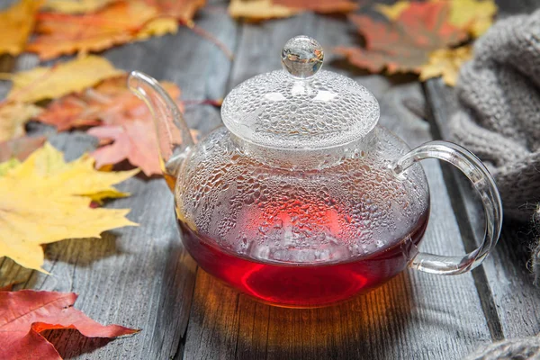 Autumn Still Life: Tea on maple leaves on a wooden table — Stock Photo, Image