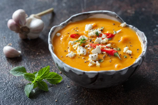 Жареная тыква и морковный суп с сыром фета и чили — стоковое фото