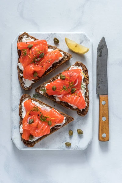 Сморреброд, традиционные датские открытые санвичи, темный ржаной хлеб с лососем, сливочный сыр и каперсы . — стоковое фото