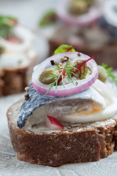 Открытый сэндвич смореброд с сельдью, луком и яйцами — стоковое фото