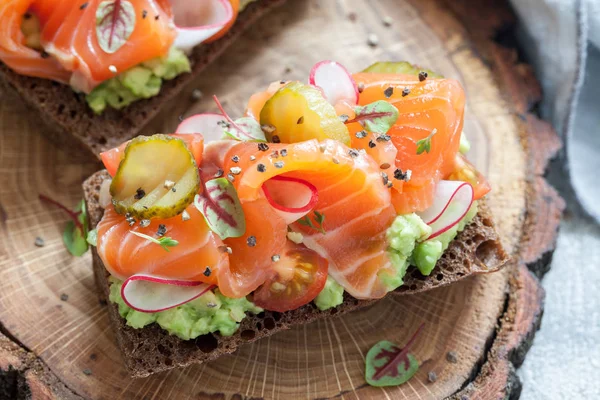 Smorrebrod dengan salmon pada roti gandum dengan sayuran dan rempah-rempah — Stok Foto