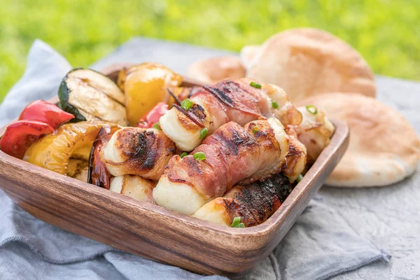 Grilled bacon wrapped haloumi with vegetables and pita — Stock Photo, Image