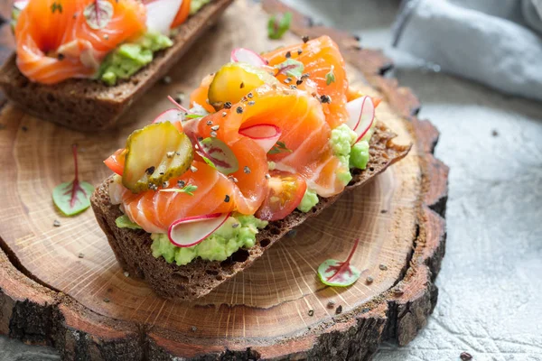 Smorrebrod с лососиной на ржаном хлебе с овощами и травами — стоковое фото