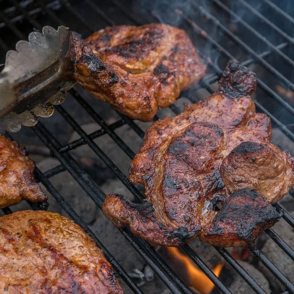 Pork steak meat on bbq grill — Stock Photo, Image