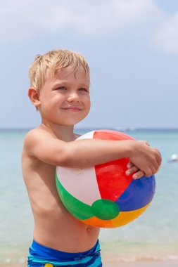 Çocuk kum ve dalgalar kumsalda oynarken