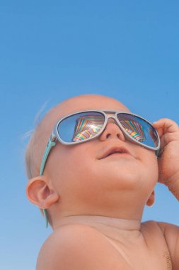 Mutlu komik gülümseyen şirin bebek çocuk güneş gözlüğü ile