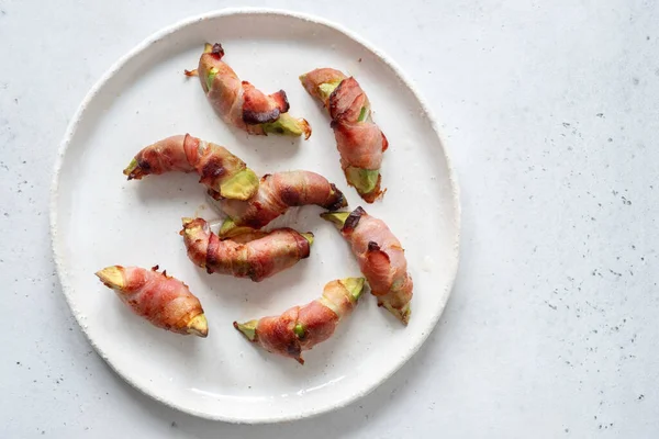Pedaços de abacate torrados embrulhados em bacon — Fotografia de Stock