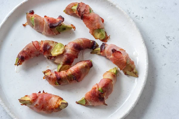 Pedaços de abacate torrados embrulhados em bacon — Fotografia de Stock