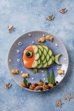 Çocukların öğle yemeği için komik somon sandviçi.