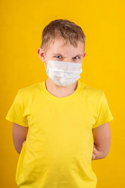 Chico guapo en máscara protectora sobre un fondo amarillo —  Fotos de Stock