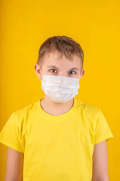 Beau garçon dans un masque de protection sur un fond jaune — Photo