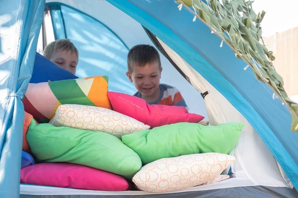 Cute boys playing with pillow inside tent — Stock Photo, Image