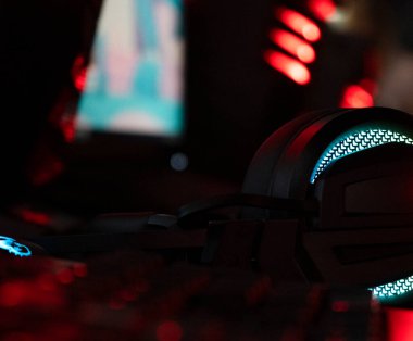 RBG ışıkları arasında arka planda bir PC ile kulaklık çalmak