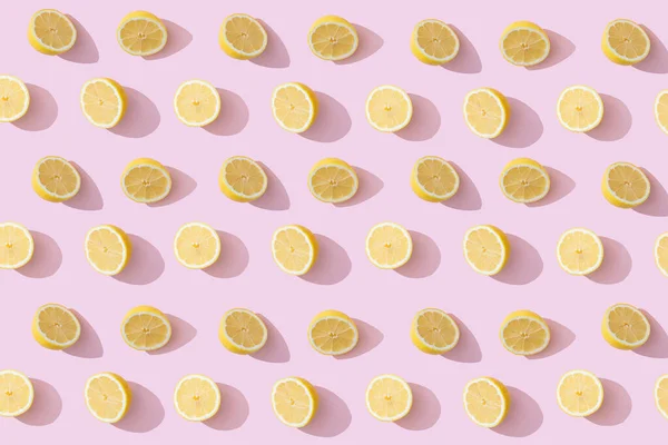 Trendy summer pattern with yellow lemon slices on bright pink background. Minimal summer concept.