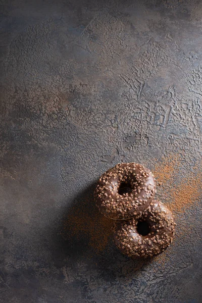 Chocolate gluten free donuts on dark concrete background. Top view, copy space for text. Bakery banner, poster, menu