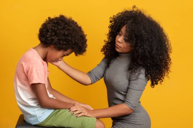 Endişeli Afrikalı Amerikalı anne, üzgün, küçük melez oğlunun elini tutarak destek veriyor ve teselli ediyor, siyah anne koruyucu aile çocuğu..