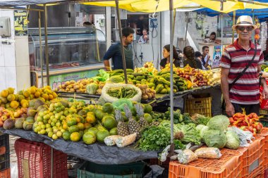 Sokak pazarında yürüyen insanlar. Sebzeler gün içinde caddeden alışveriş yapıyor. 