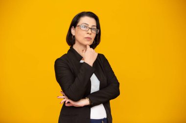 Sarı duvarda güzel gülüşü olan çekici orta yaşlı kadın. Oldukça yaşlı bir iş kadını, kolları bağlı başarılı bir güven..