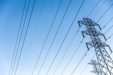 Yüksek voltajlı güç iletim kulelerine bak. Mavi gökyüzü.