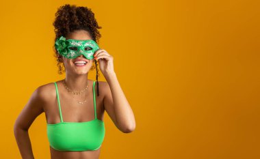 Karnaval gecesi için giyinmiş güzel bir kadın. Renkli maskesiyle karnavalın tadını çıkarmaya hazır gülümseyen kadın. Yukarıya işaret ediliyor.