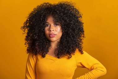 Kıvırcık saçlı, kameraya bakıp gülümseyen genç Afro-Amerikalı kadın. Kıvırcık saçlı, kameraya bakıp gülümseyen tatlı afro kız..