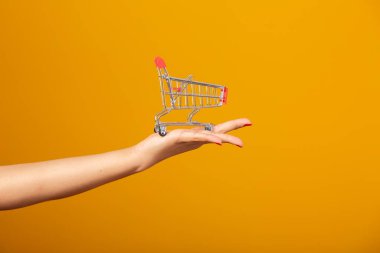 Kadın ve süpermarket, mini bir araba gösteriyor. Promosyon alışveriş konsepti.