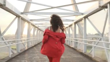 Kıvırcık kadın köprüde dans ediyor